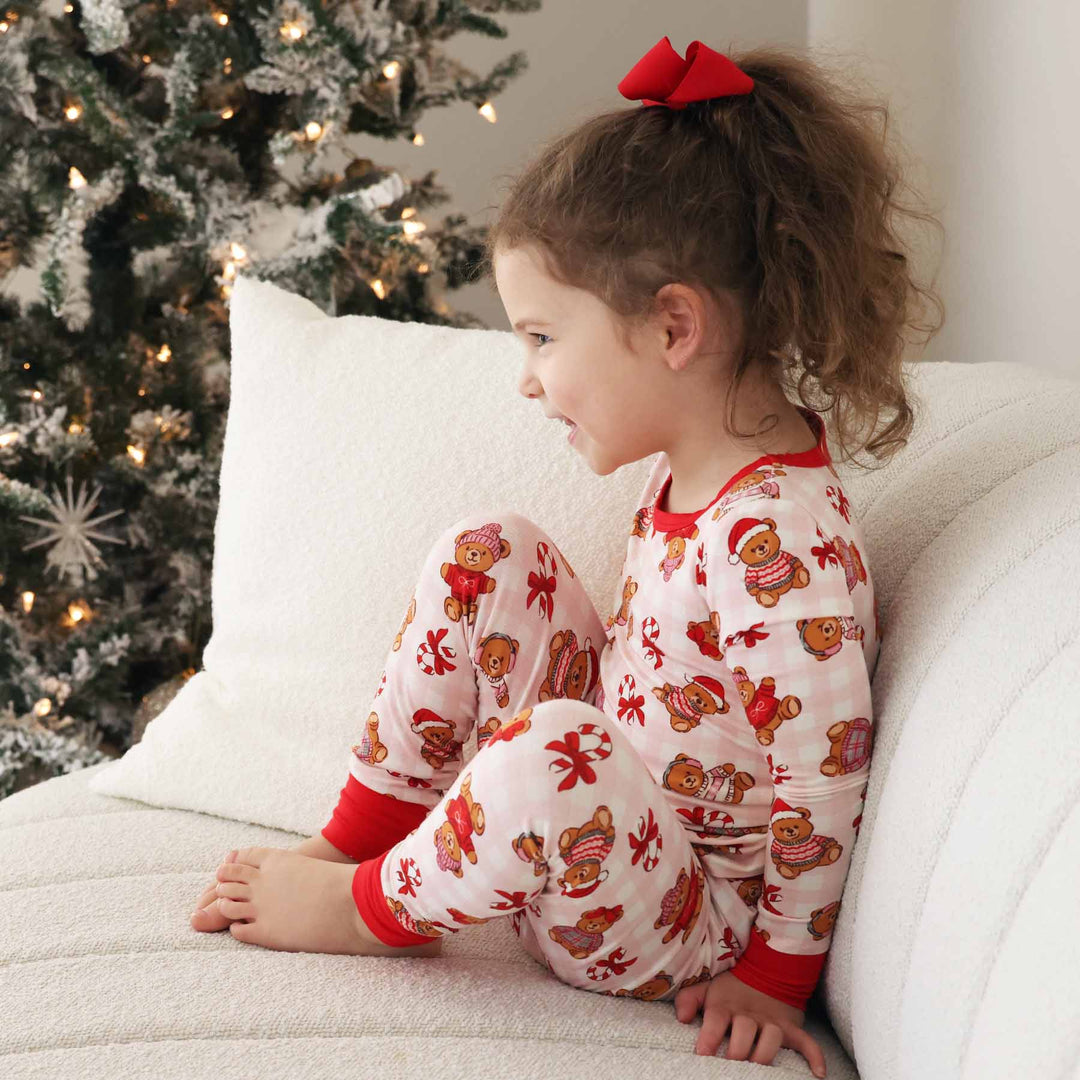girls two piece pajama set for christmas with teddy bears dressed in sweaters sprinkled with candy canes wrapped in bows 