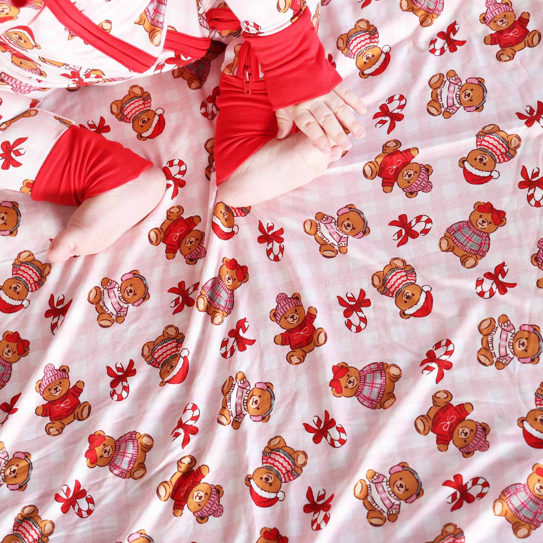 pink and white gingham bamboo blanket with teddy bears dressed in christmas sweaters with candy canes a red trim