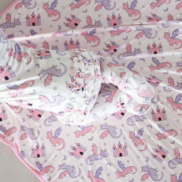 baby wearing ruffle bottom zipper footie for girls with dragons and castles 