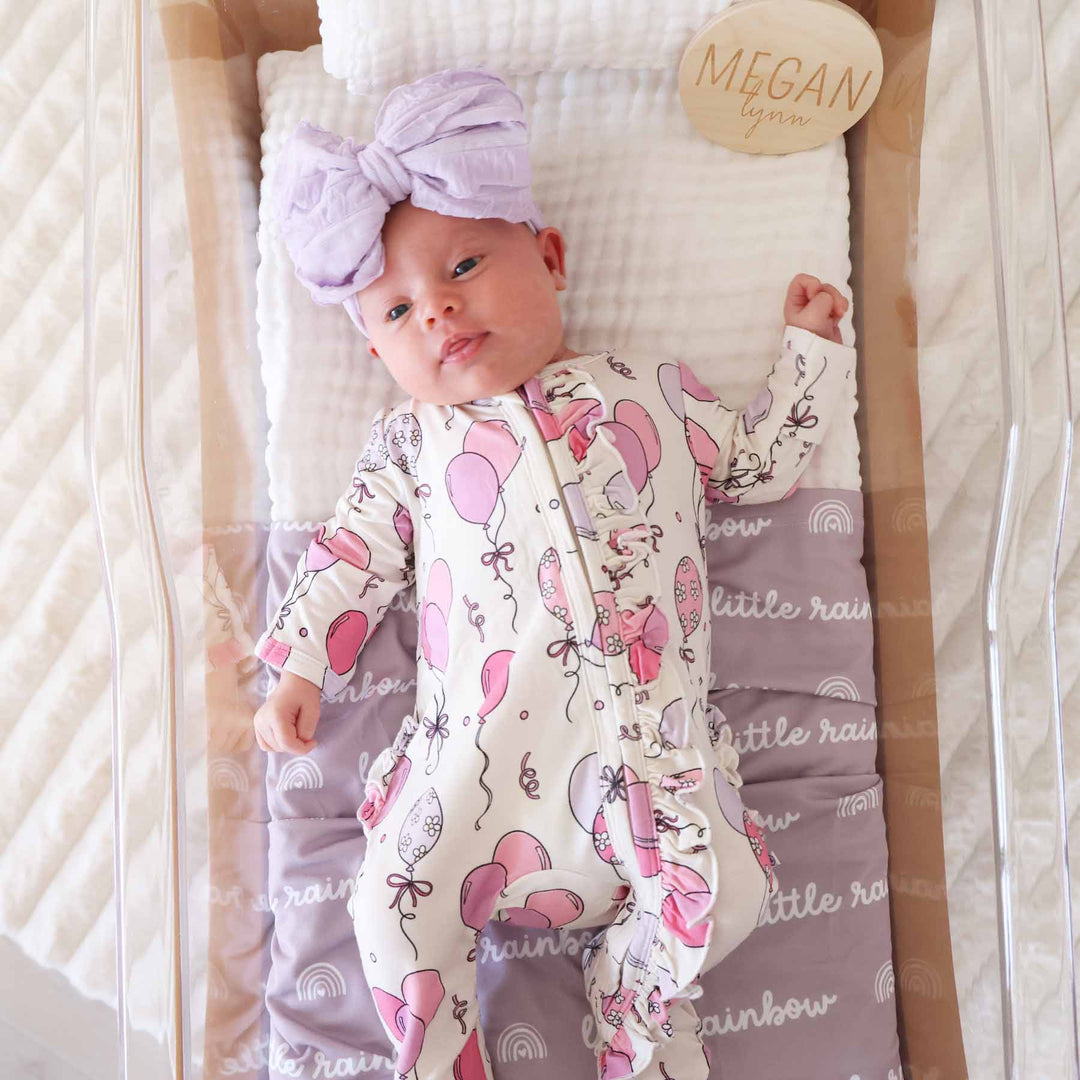birthday themed ruffle zipper footie for baby girls with pink and purple balloons 