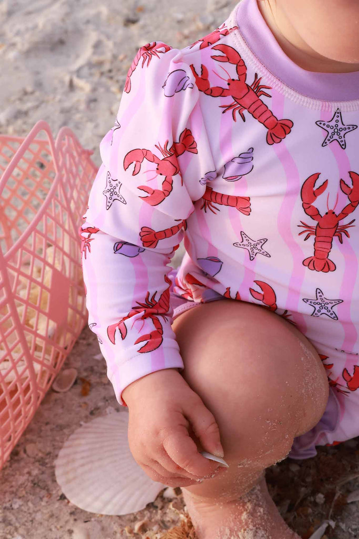pinch me lobster, seashell and starfish long sleeve rash guard swimsuit with pink squiggles