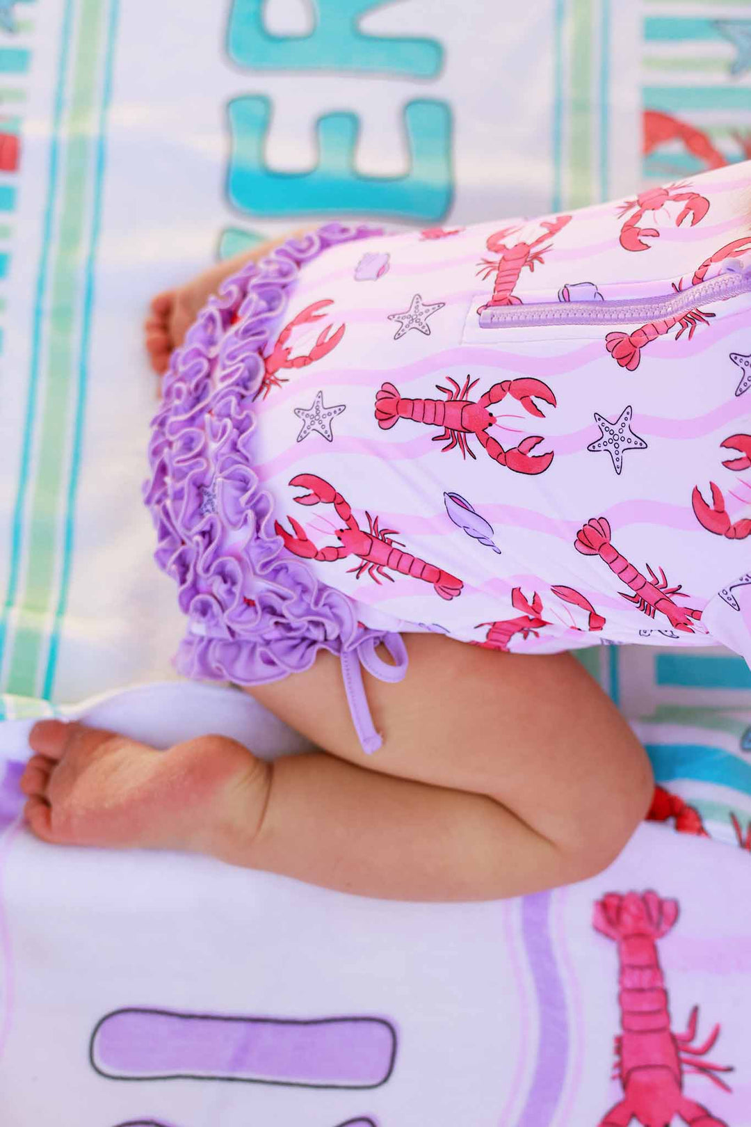 closeup of pinch me pink long sleeve rash guard with ruffle bottom 