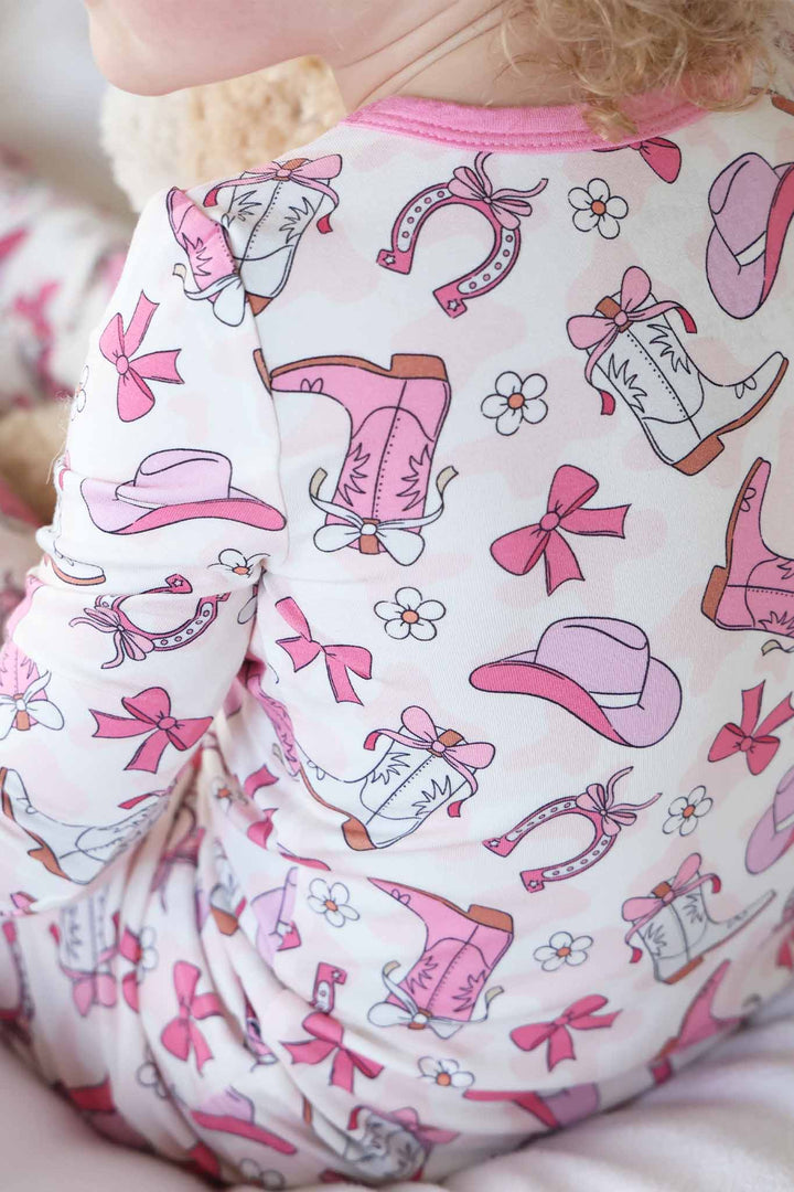 pink rodeo dreams pajama print with cowgirl boots, hats, horseshoes, bows and daisies 