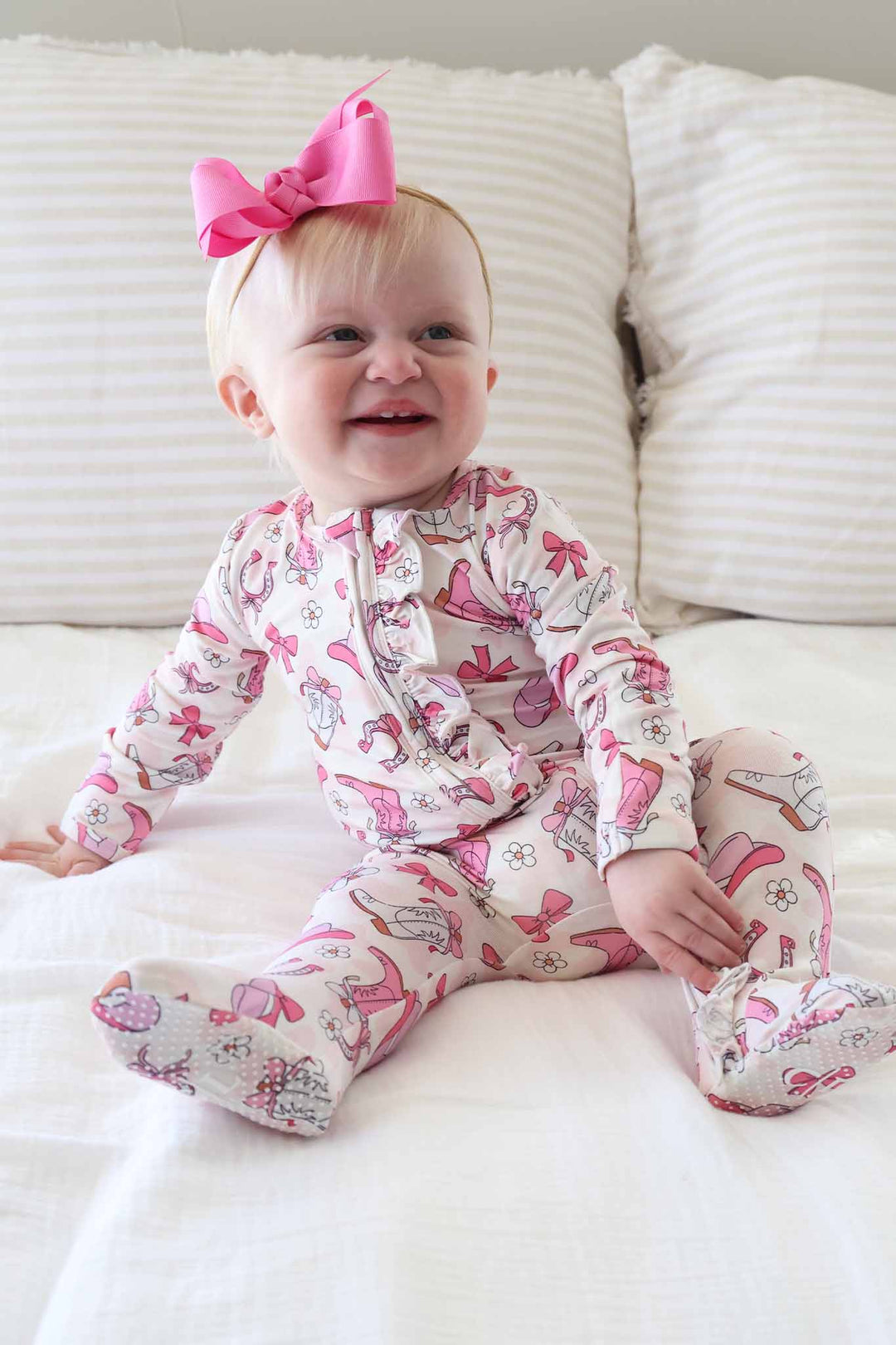 pink rodeo dreams ruffle zipper footie pajama for baby girls with matching pink ribbon bow headband 
