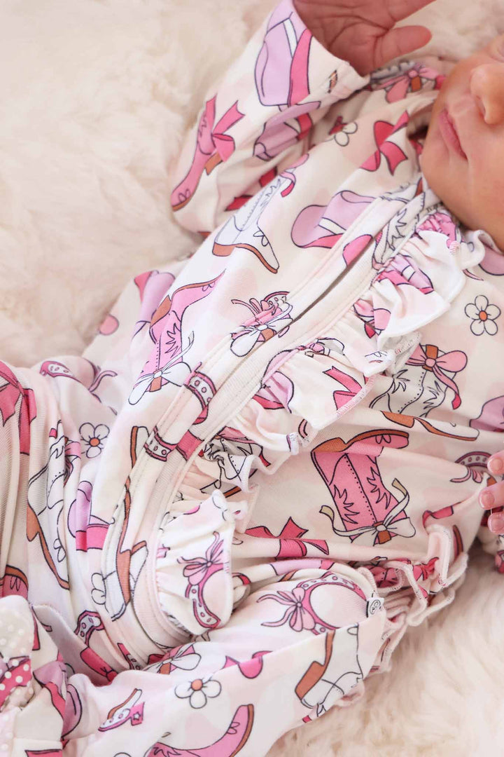closeup of pink rodeo dreams zipper footie with ruffle along the zipper 