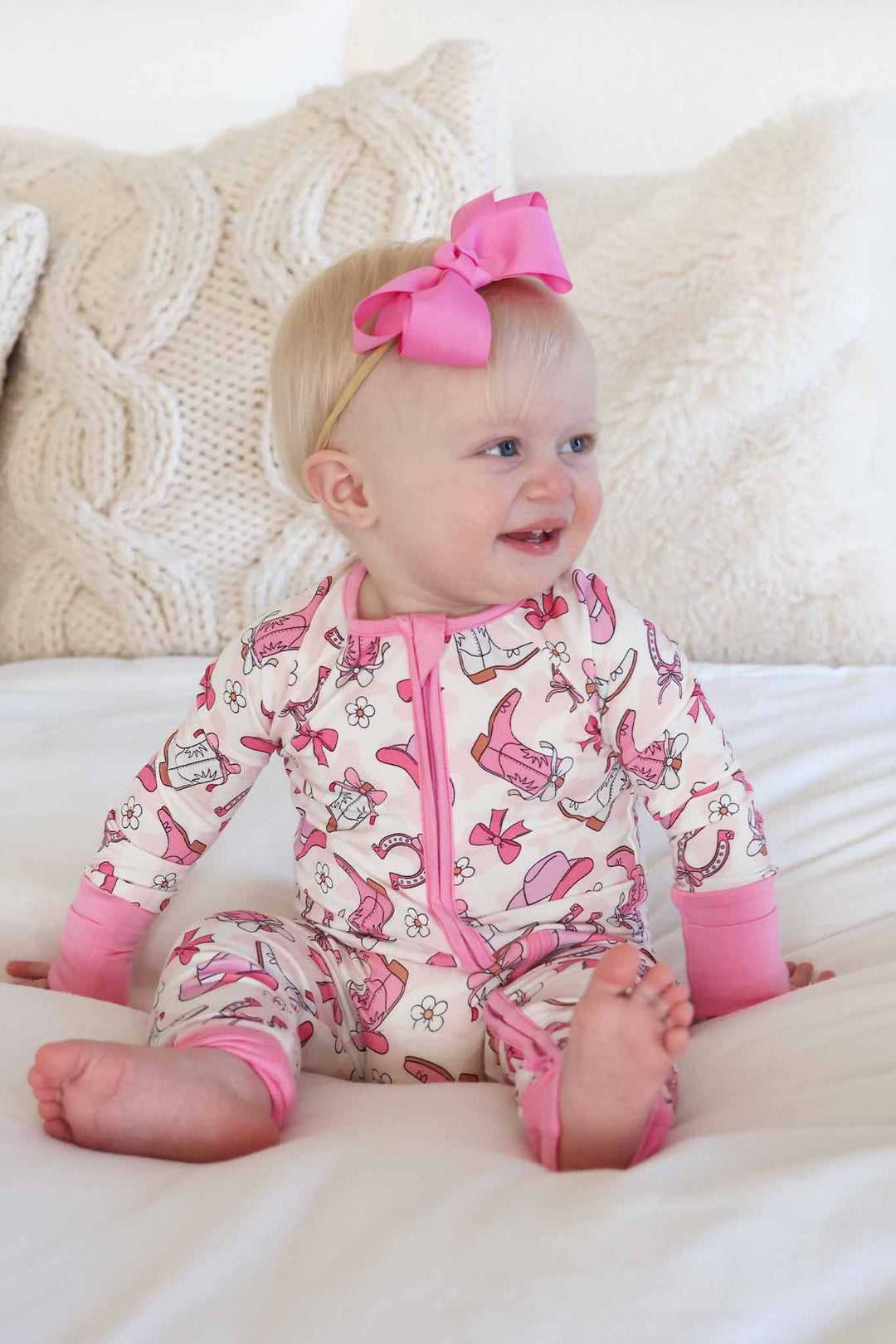 baby girl wearing pink rodeo dreams convertible zip romper pajama with matching hot pink ribbon bow headband 