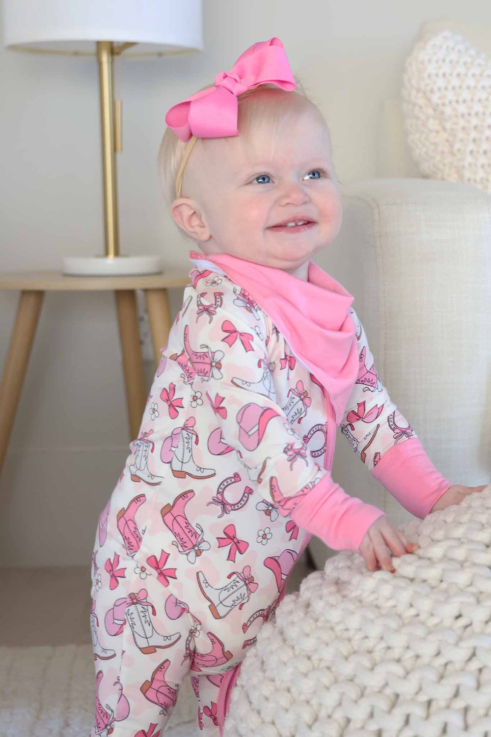 baby girl wearing a pink western themed convertible zip romper wearing a pink bandana bib 