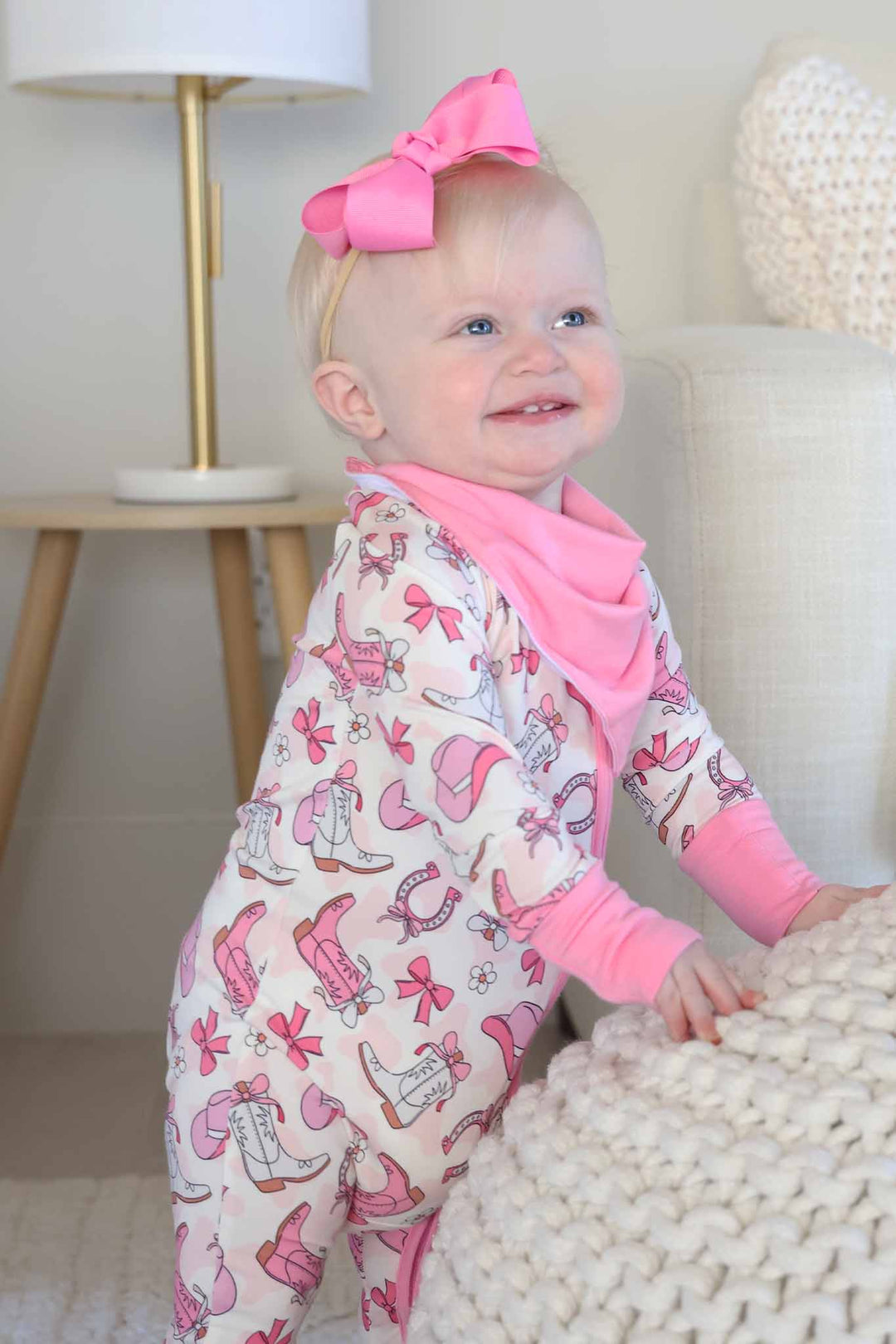 baby girl wearing a pink western themed convertible zip romper wearing a pink bandana bib 