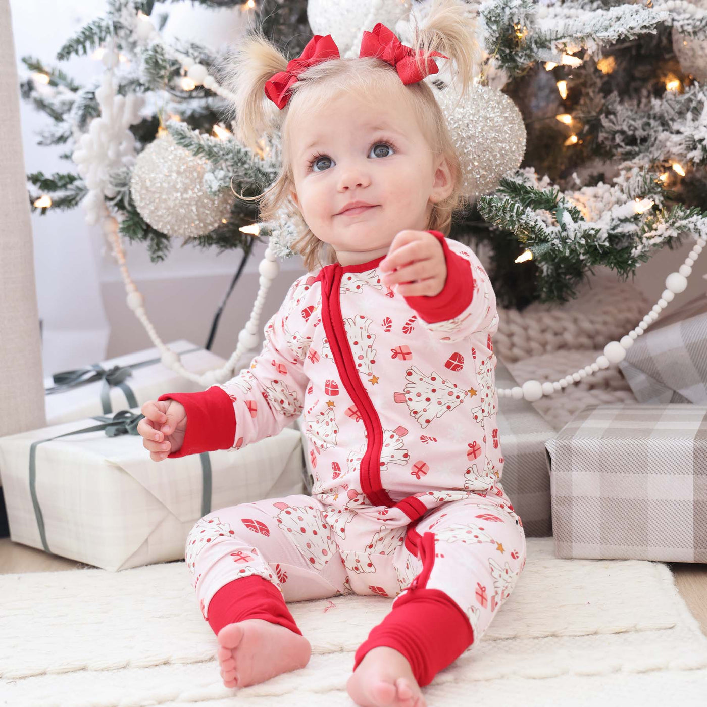 pink baby pajama romper christmas trees, presents and candy canes 