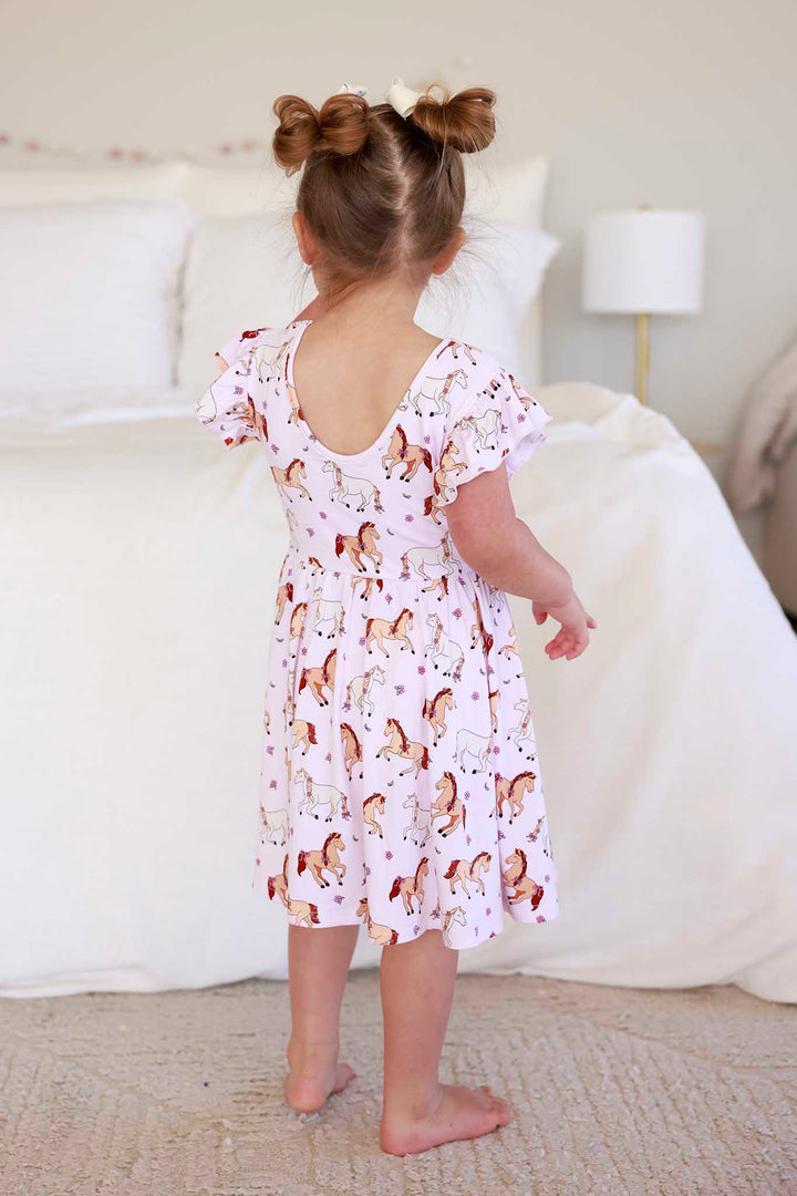 back view of girls ruffle twirl dress in pink pony club print 