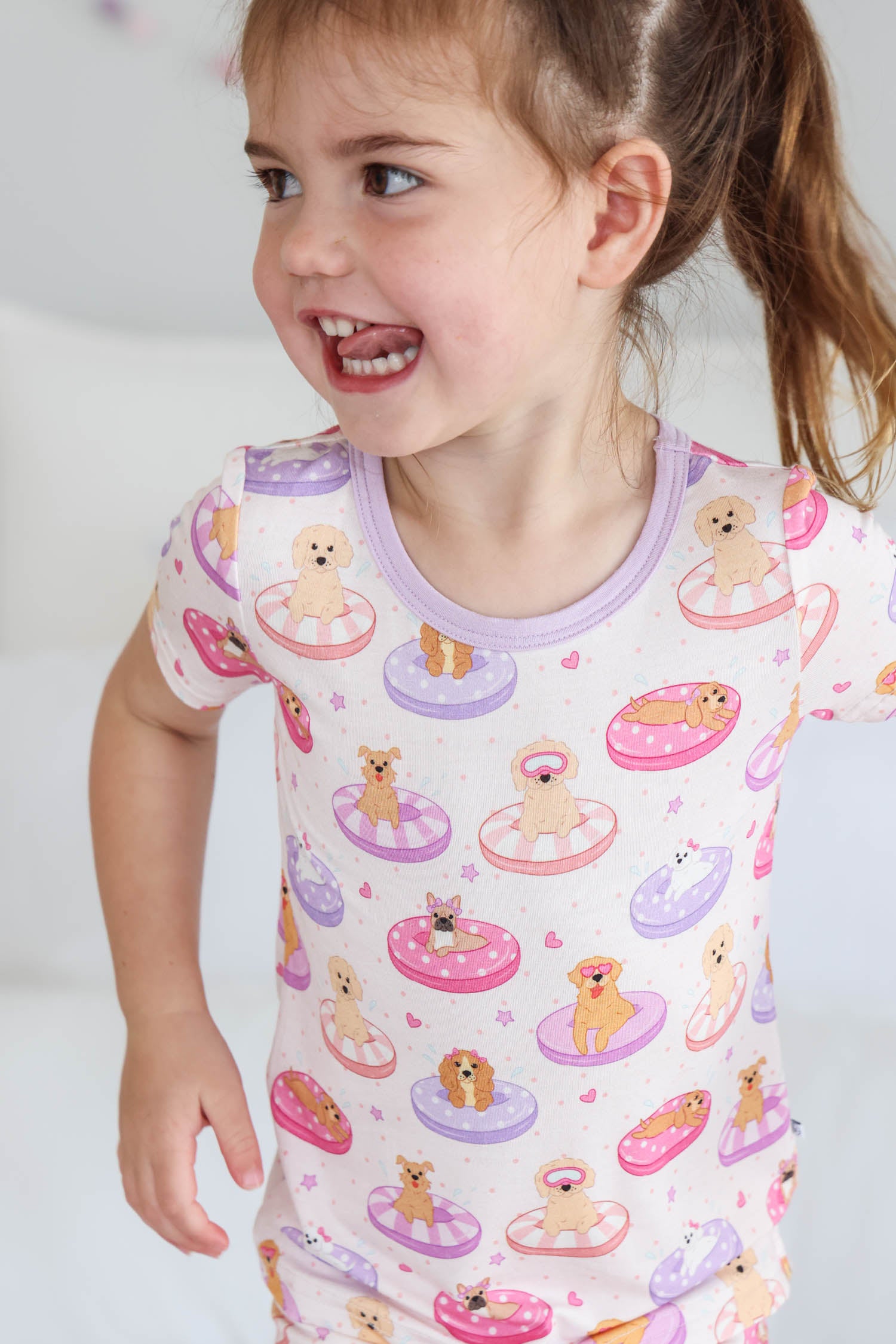 girl with tongue sticking out wearing the poolside pups two piece pajama set