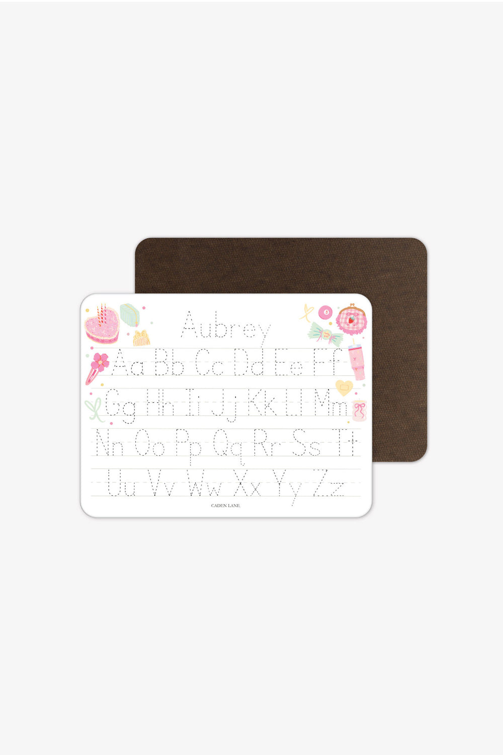Front and back view of a personalized Caden Lane Pretty in Pink alphabet whiteboard with dark wood-grain back, showing birthday cake, tumbler, and bows with tracing letters and custom name