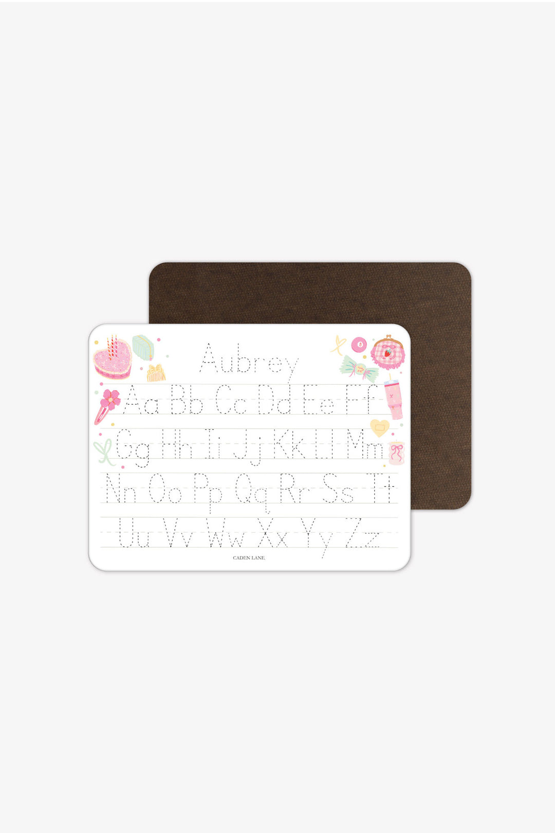 Front and back view of a personalized Caden Lane Pretty in Pink alphabet whiteboard with dark wood-grain back, showing birthday cake, tumbler, and bows with tracing letters and custom name