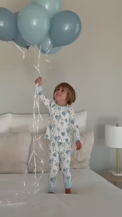 boy in blue balloon pajamas holding balloons
