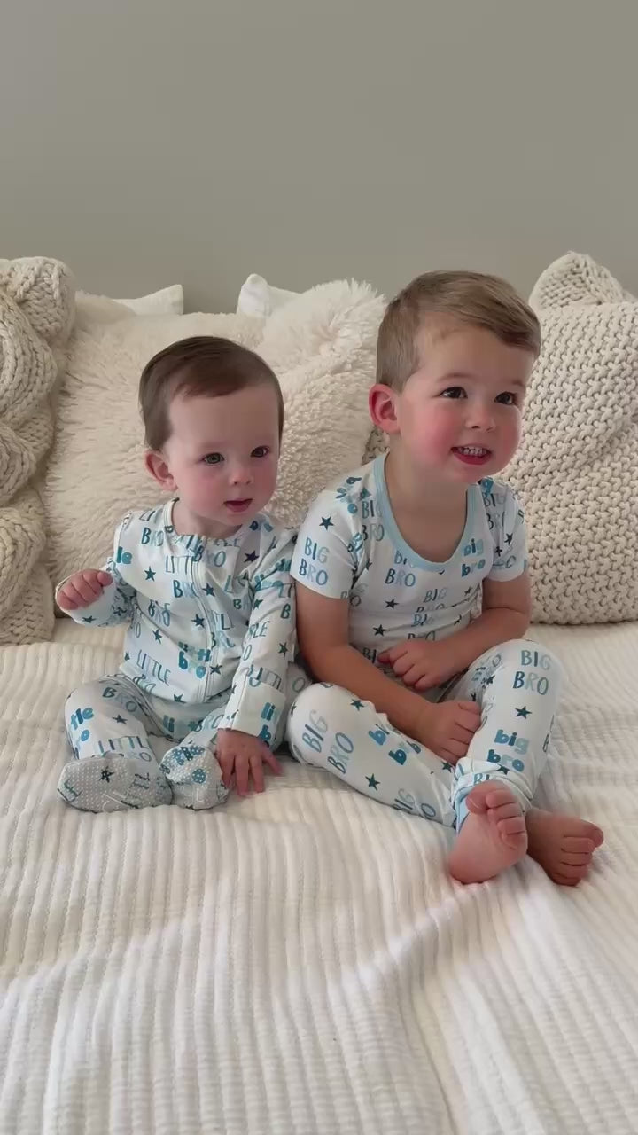 two brothers sitting next to each in big and little bro pajamas - video