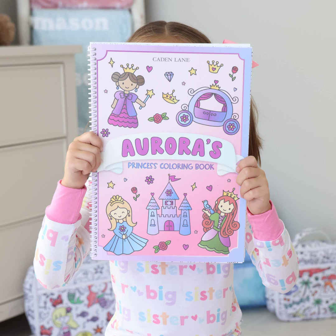 girl holding a personalized princess themed coloring book 