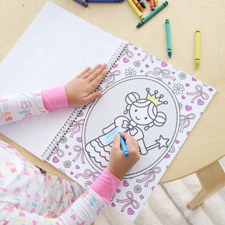 little girl coloring a princess coloring book 