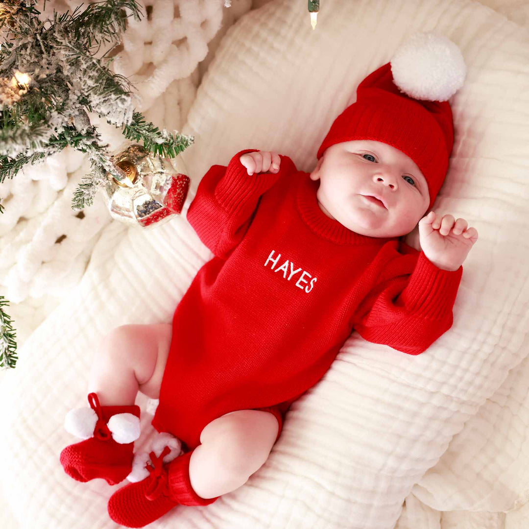 bright red personalized knit sweater bubble romper for babies for christmas with matching pom pom beanie and booties 