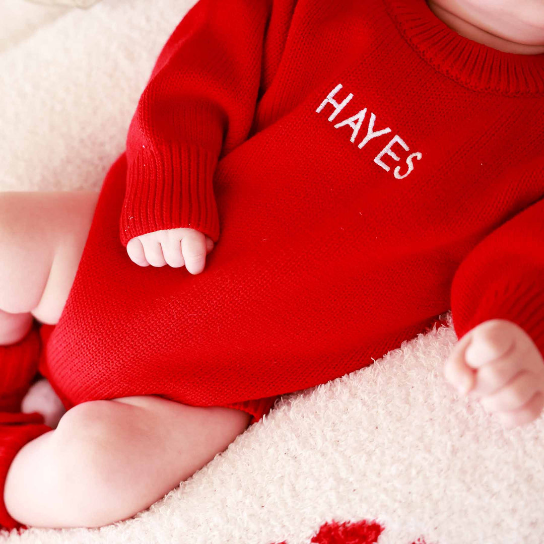 embroidered sweater bubble romper for babies bright red for christmas with white thread and block font 