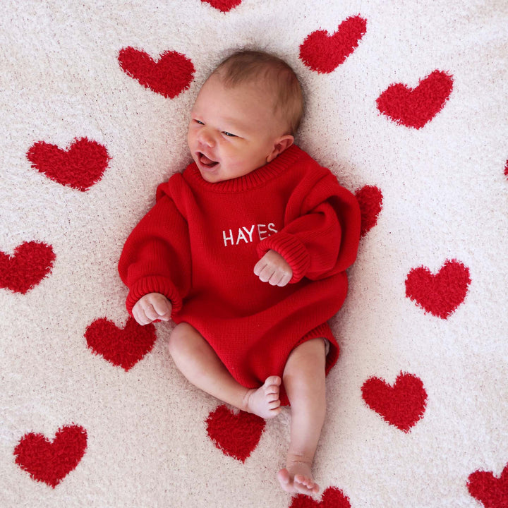 baby wearing an embroidered red sweater bubble romper 