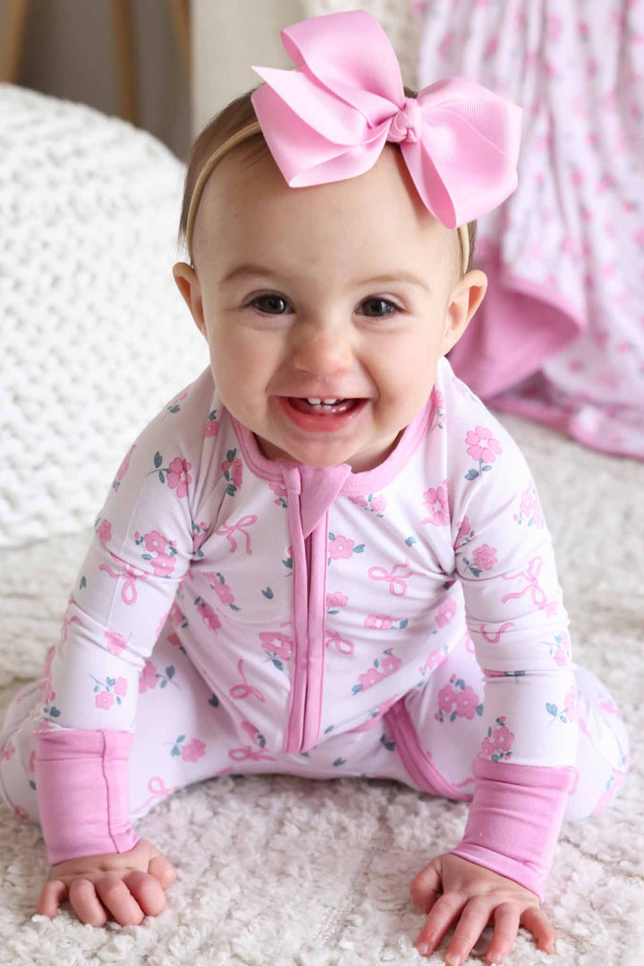 crawling baby girl wearing pink flower and ribbon bow convertible zip romper pajama 