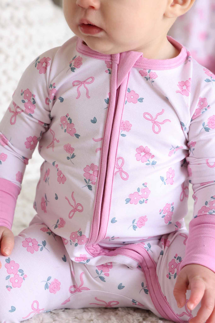 closeup of pink ribbon and roses convertible zip romper pajama for baby and toddler girls 