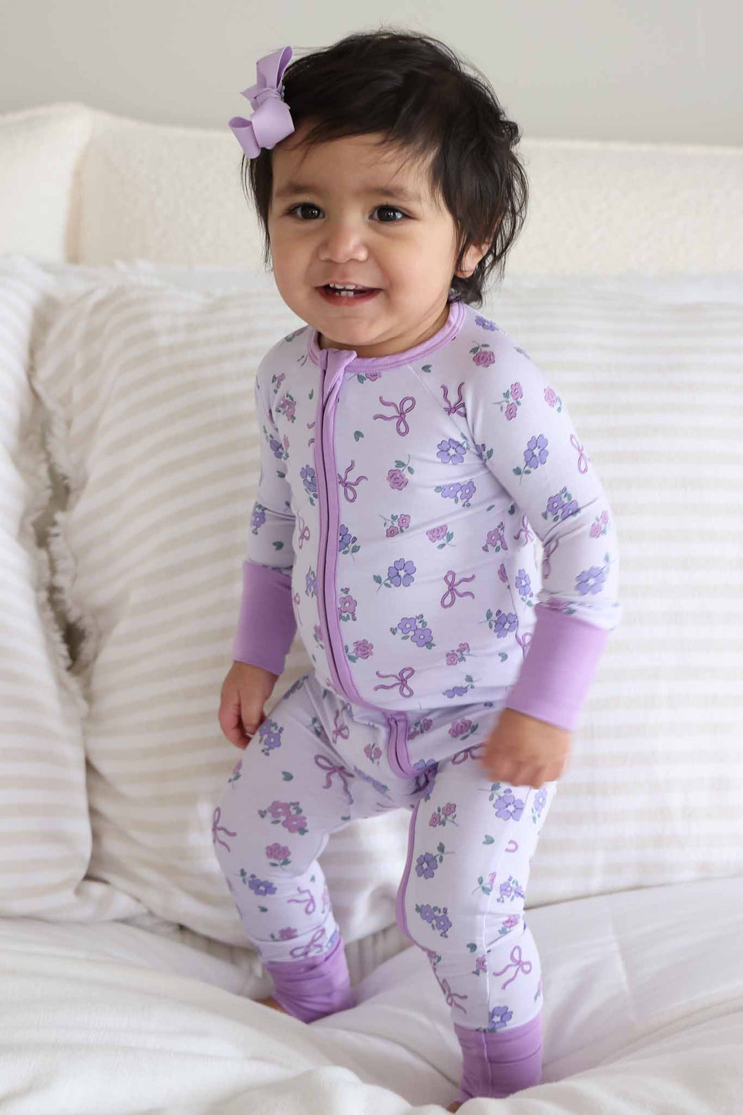 girl jumping on bed in ribbon and roses purple convertible zip romper 