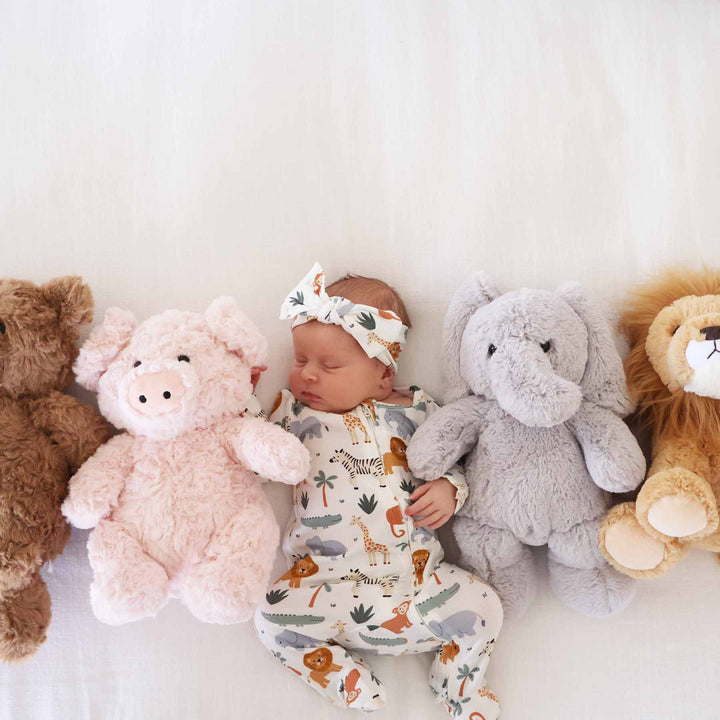 baby wearing safari animal footie with bear, pig, elephant and lion stuffed animals 