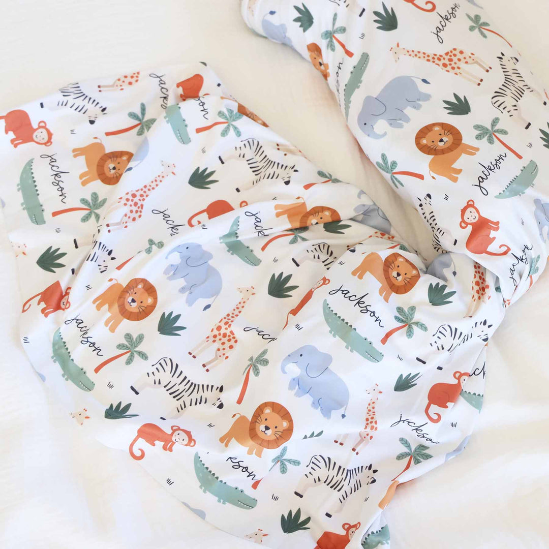 oversized personalized white swaddle blanket with lions, elephants, crocodiles, zebras and palm trees