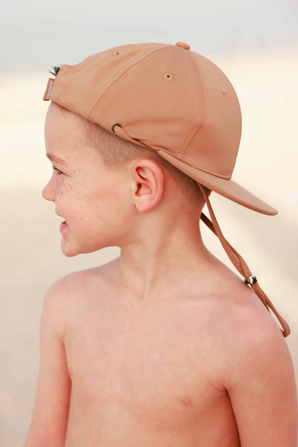boy wearing medium brown swim baseball cap with adjustable strap