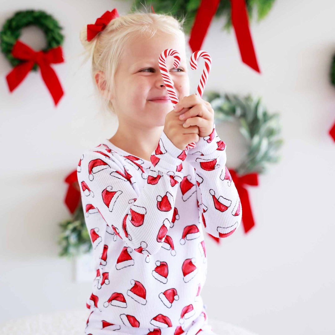 sibling matching christmas pajamas with santa hats 