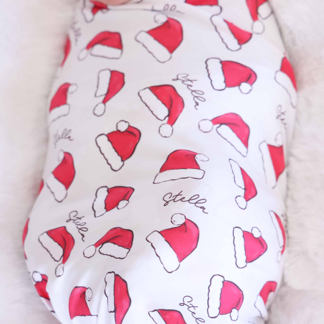 personalized christmas swaddle blanket for babies with red santa hats 