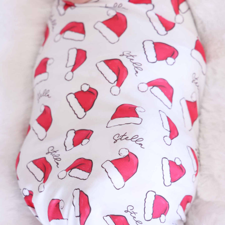 personalized christmas swaddle blanket for babies with red santa hats 