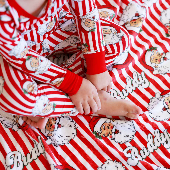 Close up of Santa Claus Lane Personalized Kids Blanket with little boy wearing matching Two Piece Pajama Set
