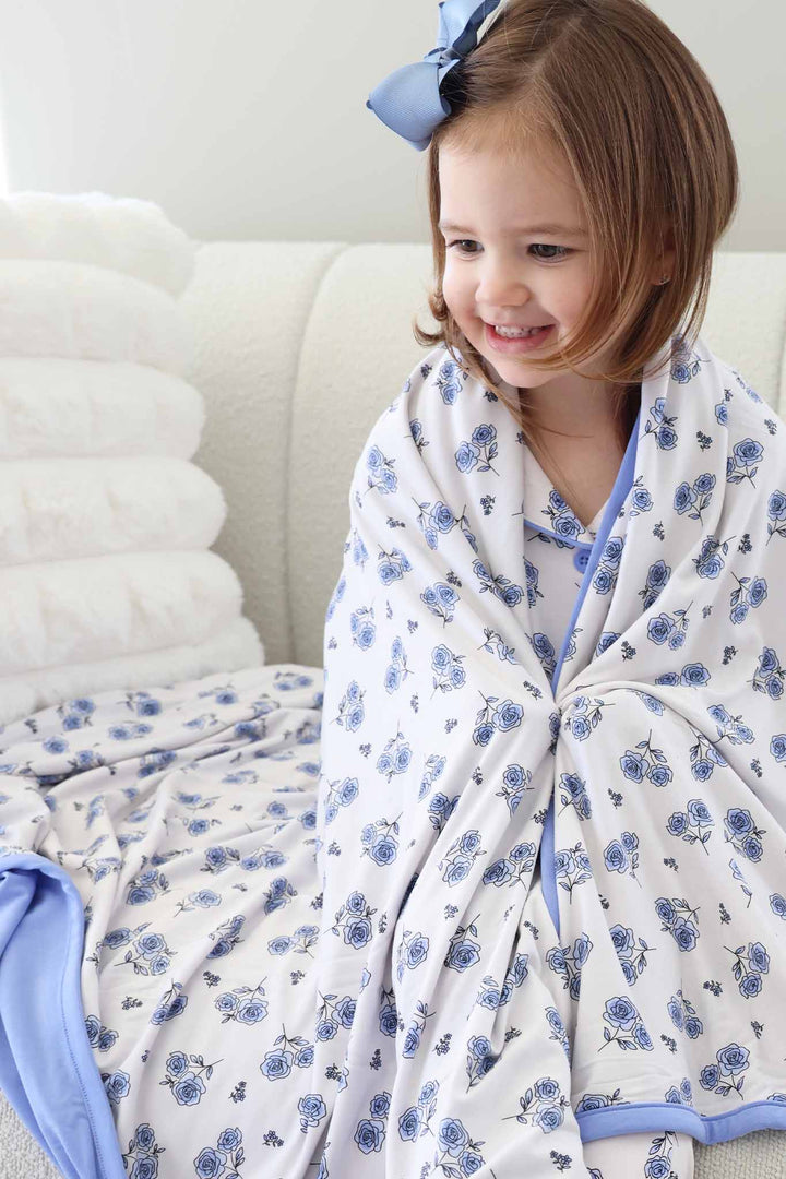 closeup of blue rose double sided bamboo blanket for girls with matching lounge set and blue clip bow