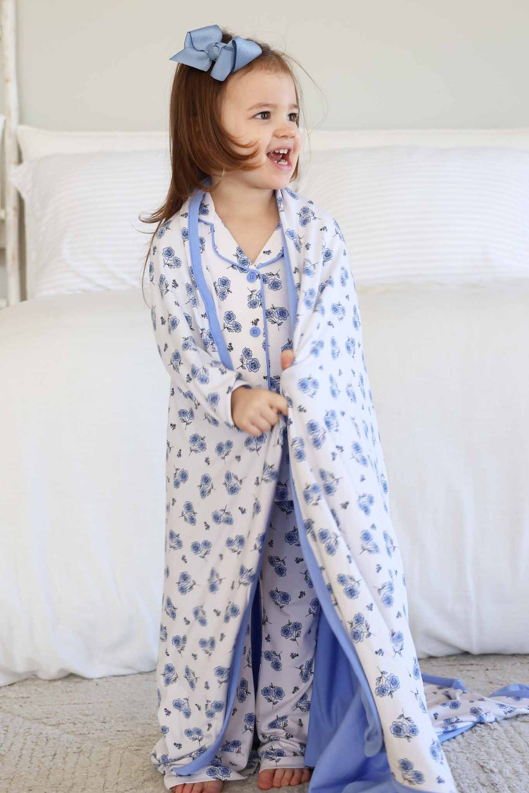 girl looking to the side in blue rose lounge set with matching bamboo blanket wrapped around her 