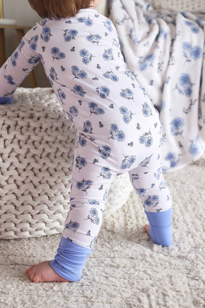 baby girl leaning on ottoman in sapphire garden convertible zip romper pajama for baby and toddler girls 