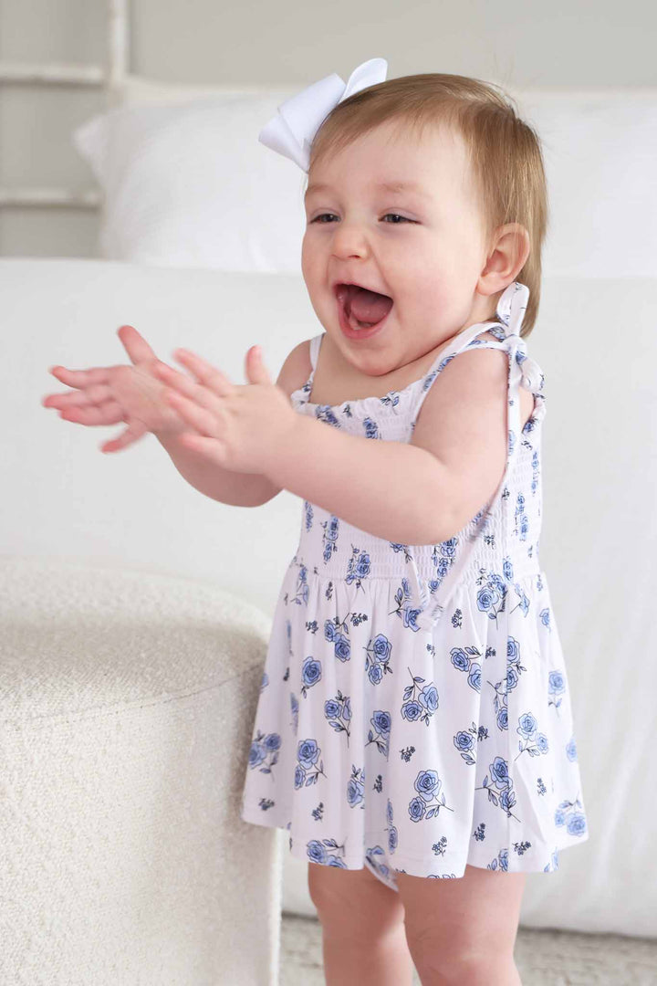 baby girl clapping wearing sapphire garden spaghetti strap bow shoulder bodysuit with skirt 