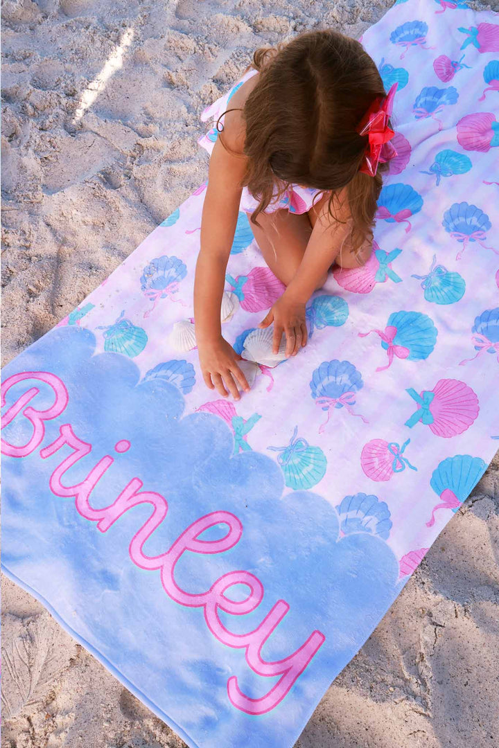 girl sitting on personalized beach towel in seaside sweetie