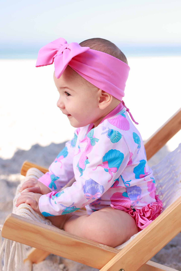side view of seaside sweetie seashell rash guard swimsuit with ruffle bottom 