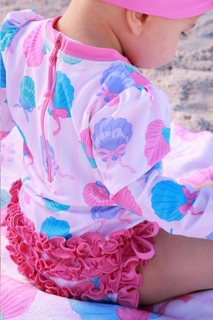 closeup of seaside sweetie rash guard print with pink ruffles on the bottom 