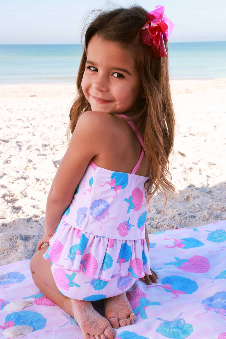 girl sitting on the beach in strappy two piece tankini in seaside sweetie 