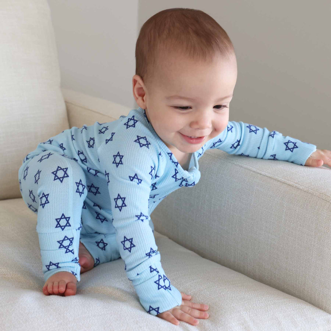 baby boy crawling on chair wearing blue star of david hanukkah convertible zip romper 
