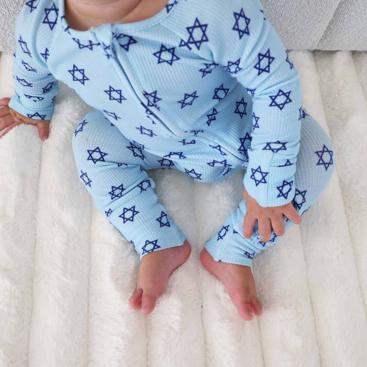 toddler sitting on ground wearing gender neutral bamboo waffle hanukkah zip romper