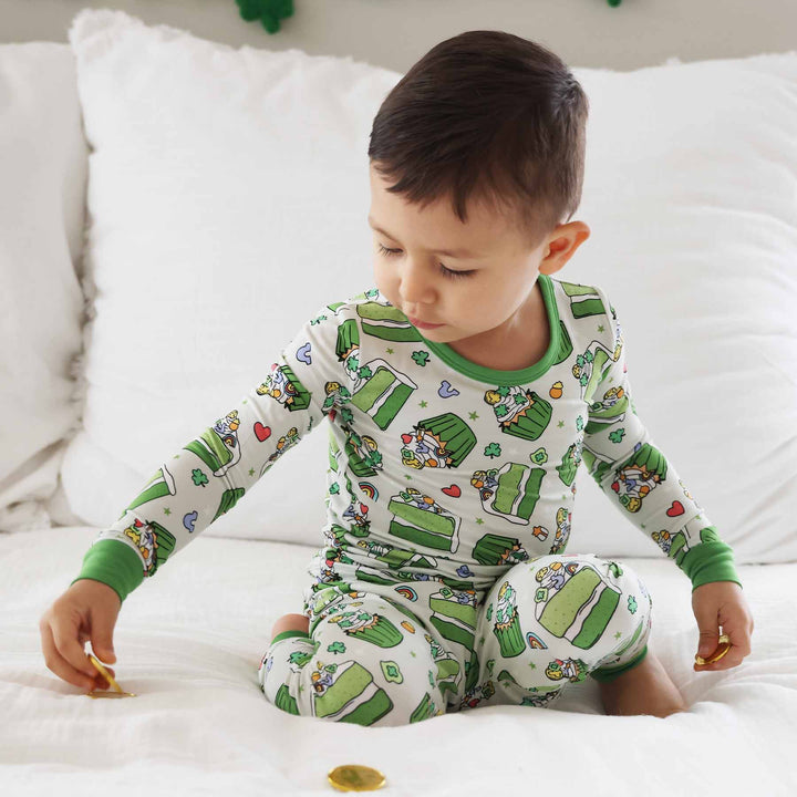 boy wearing shamrock sweets two piece pajama set playing with fake gold coins 