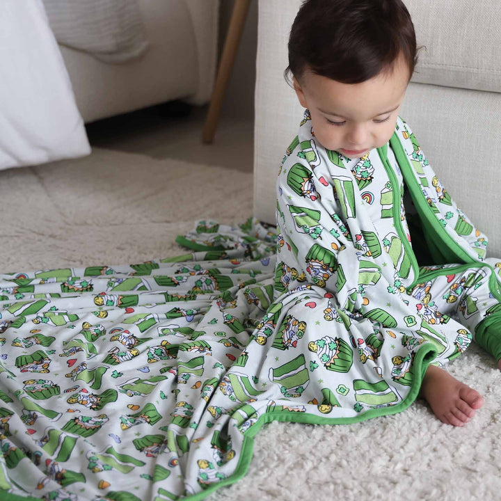 Baby wearing the Shamrock Sweets zip romper and matching Double Sided Bamboo Blanket
