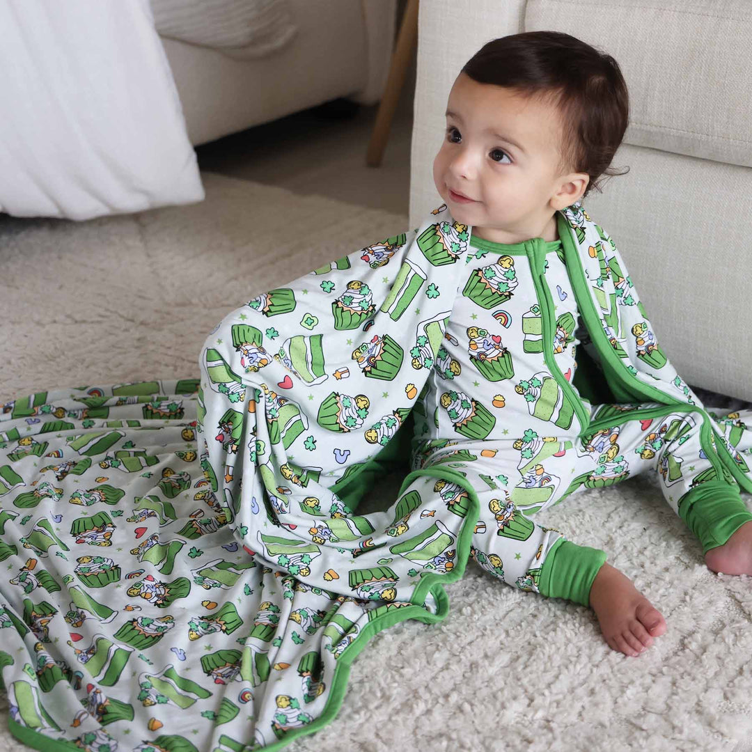 Baby wearing the Shamrock Sweets zip romper and matching Double Sided Bamboo Blanket