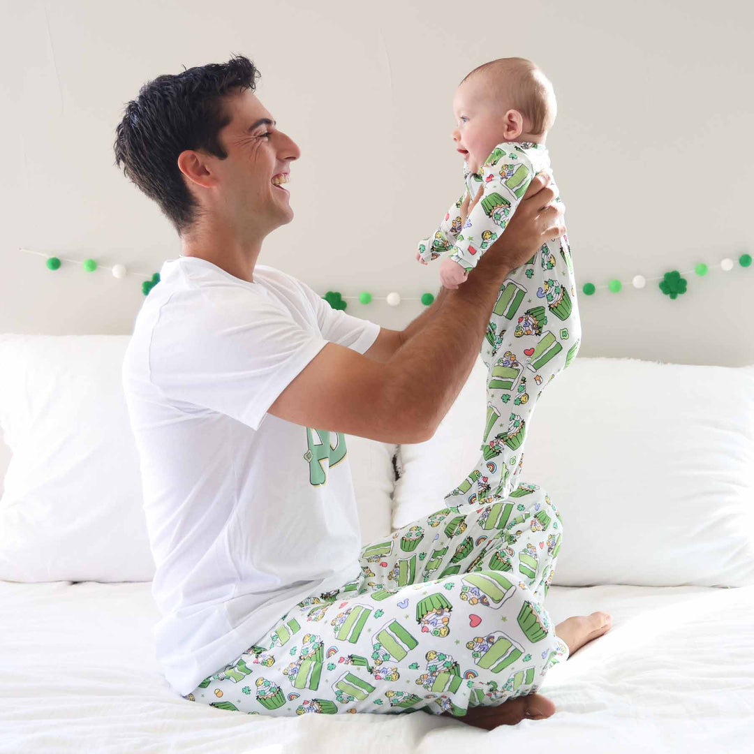 dad holding up baby wearing matching st. patrick's day pajamas 