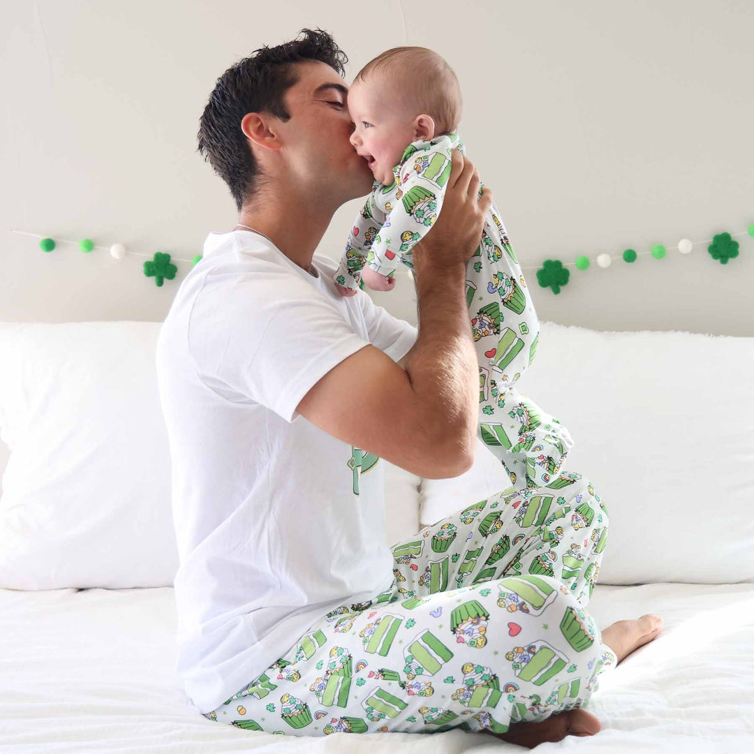dad kissing baby wearing matching st. patrick's day pajamas 