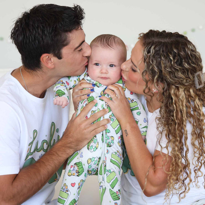 mom and dad kissing baby wearing a green dessert zipper footie for st. patrick's day 
